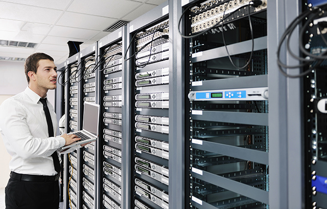 young it engeneer business man with thin modern aluminium laptop in network server room