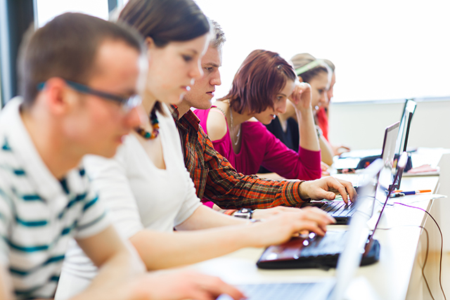 College students sitting in a classroom, using laptop computers during class (shallow DOF)